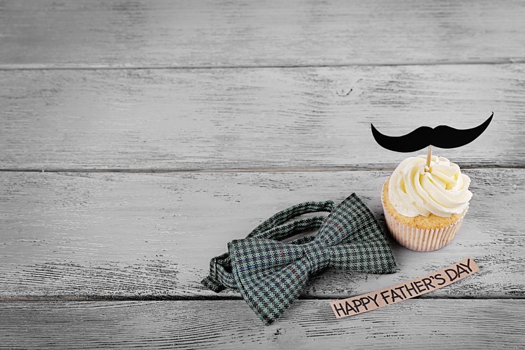 Happy fathers day special cupcake and bow tie on wooden table