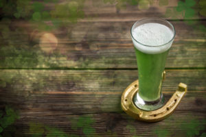 St Patricks Day green beer with horseshoe on wooden background