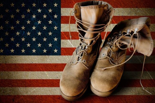 US Army boots on sandy american flag background collage