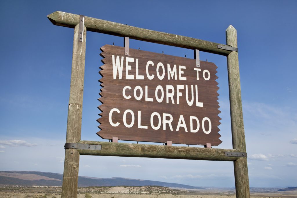 welcome to Colorado roadside wooden sign at a border with Utah in northwestern Colorado