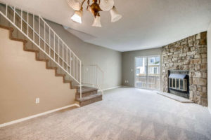 open living room with fireplace and large stone wall