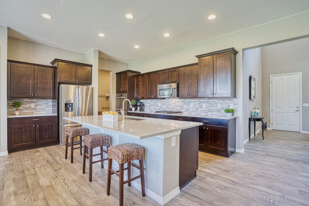 chefs kitchen with large center island stainless steel appliances and quartz countertops