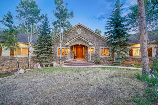 Front pic of home in the trees in Larkspur, CO with stone entrance