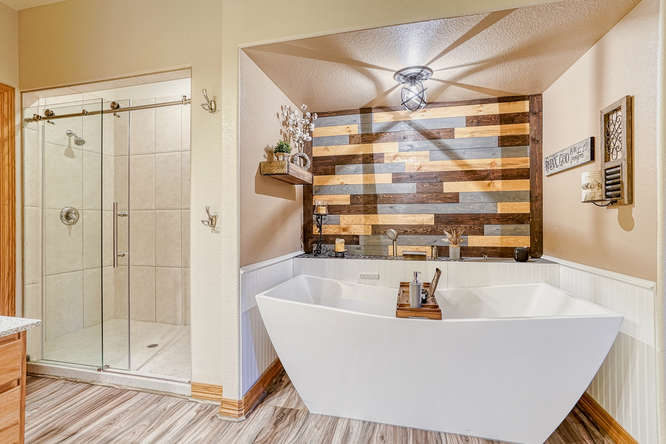 stand alone white bathtub with stained shiplap wall