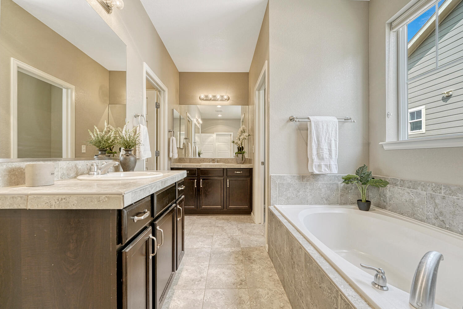 walkthrough primary bathroom with separate sinks on different walls