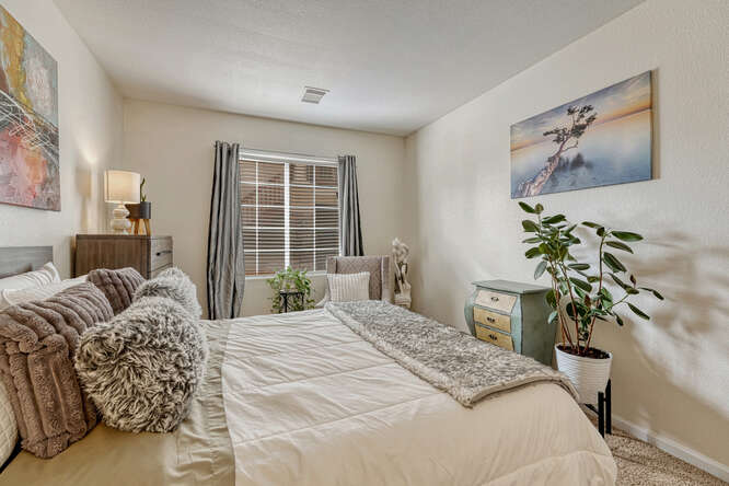 secondary bedroom with cream light walls and bedding