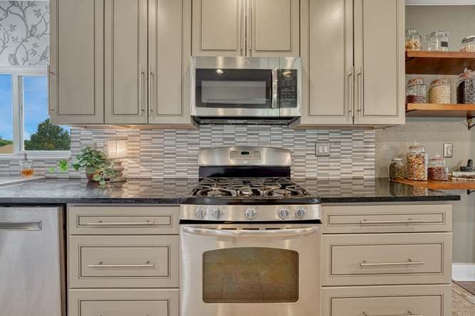 renovated kitchen with gas cooktop gray cabinets open wall shelving